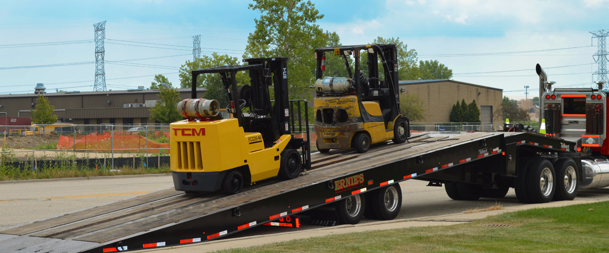 Large trailer carrying forklifts that need a used forklift price from Advantage Material Handling.