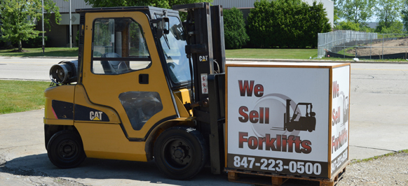 One of the used forklifts for sale holding a sell forklifts sign.